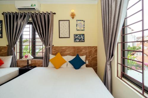 a bedroom with two beds and a window at Green Bud hostel and homestay in Hoi An