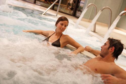 a man and a woman in a hot tub at Burntwood Court Hotel in Barnsley