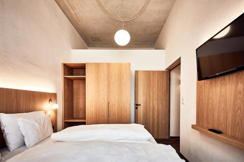 Schlafzimmer mit einem Bett und einem Flachbild-TV in der Unterkunft Hotel Walther v.d. Vogelweide Superior in Klausen
