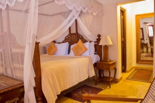- une chambre avec un lit à baldaquin dans l'établissement Beytsalam, à Lamu