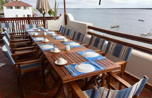 a long wooden table with blue and white plates on it at Beytsalam in Lamu