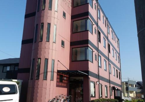 a tall pink building with a lot of windows at Omura - Hotel / Vacation STAY 46226 in Omura