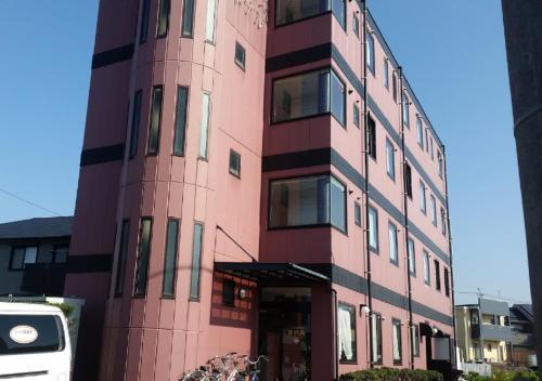a tall pink building with a lot of windows at Omura - Hotel / Vacation STAY 46228 in Omura