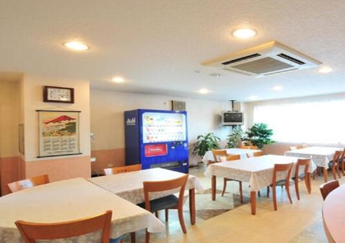 a restaurant with tables and chairs and a large screen at Omura - Hotel / Vacation STAY 46222 in Omura