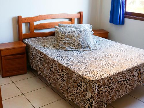 - un lit avec une estampe léopard sur celui-ci dans l'établissement Pousada Mello, à Arroio do Silva