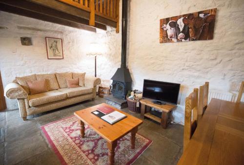 a living room with a couch and a fireplace at The Granary in Bridgend