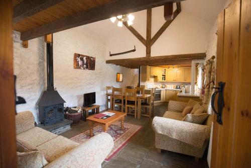 a living room with couches and a fireplace and a kitchen at The Granary in Bridgend
