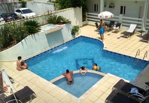 a group of people in a swimming pool at Hotel Areia Dourada in Peruíbe