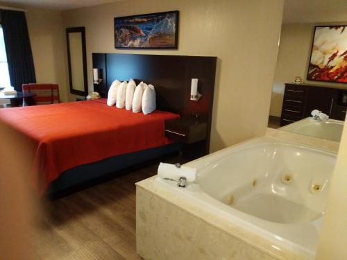 a hotel room with a bed and a bath tub at Riverside Tower in Pigeon Forge