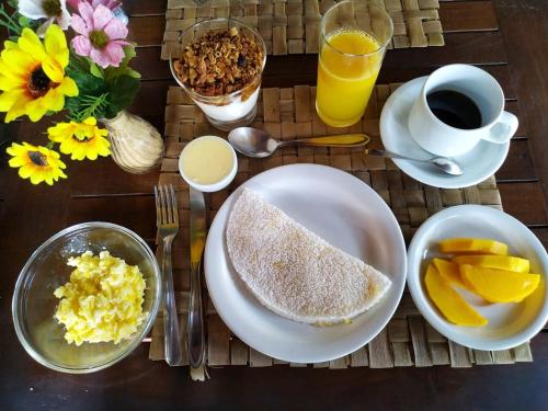 a table with a plate of breakfast food and a cup of coffee at Pousada La Villa Caraiva in Caraíva