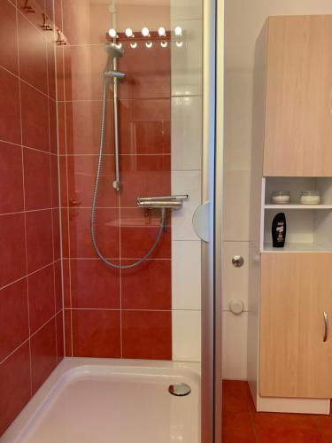 ein Bad mit einer Dusche und einer Badewanne in der Unterkunft Schöne Wohnung in Röfingen in Röfingen