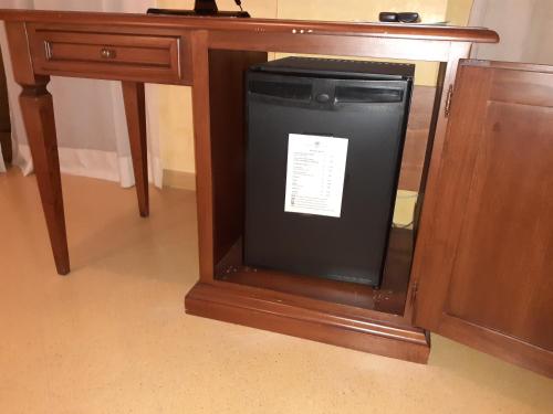 a small black refrigerator under a wooden desk at Hotel Paradiso Delle Madonie in Castelbuono