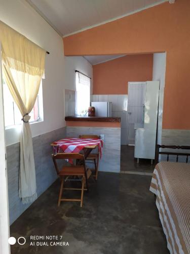 a living room with two tables and a kitchen at Pouso do Elefante in Serra do Cipo
