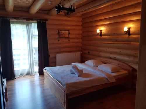 A bed or beds in a room at Casa Pădurarului