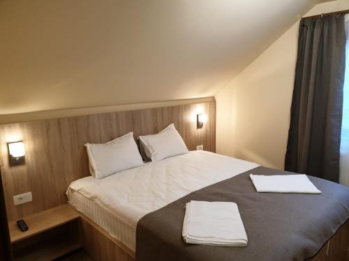 1 dormitorio con 1 cama con 2 toallas en Casa Enescu, en Bran