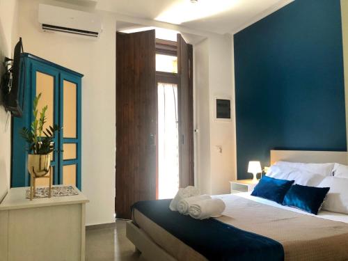 a bedroom with a large bed with a blue wall at CIVITAS 2 in Catania