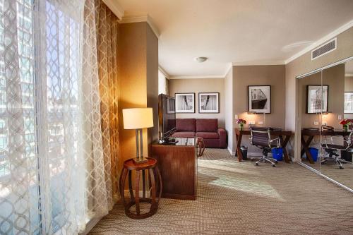 a living room with a couch and a desk at Pinnacle Hotel at the Pier in North Vancouver