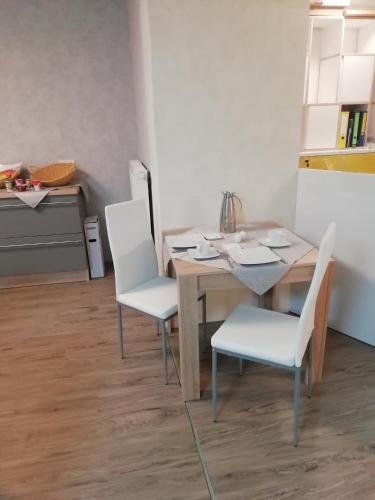 a table and chairs in a room with a kitchen at Gästehaus - Café Frank in Antweiler