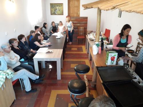 un groupe de personnes assises à des tables dans une pièce dans l'établissement Privatni smještaj Tolić, à Ladimirevci