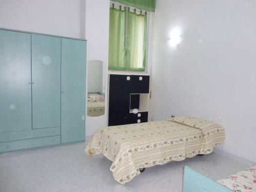 - une chambre avec un lit et une armoire bleue dans l'établissement Casa vacanza a due passi dal mare, à Alghero