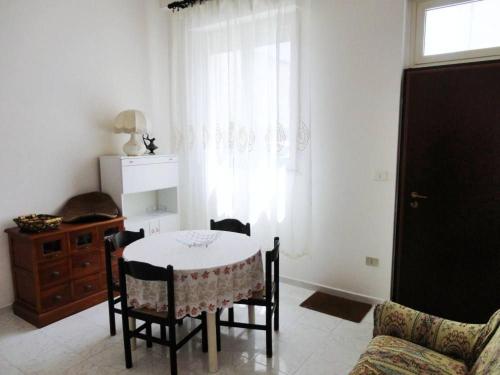 salon ze stołem i krzesłami oraz oknem w obiekcie Casa vacanza a due passi dal mare w mieście Alghero