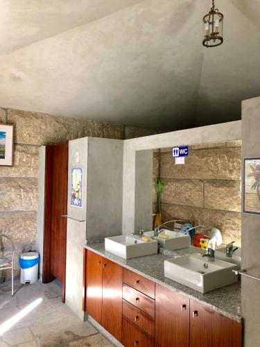 a bathroom with two sinks and two mirrors at Casa da Quinta da Prelada Simão in Celorico de Basto