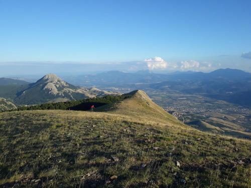 a person standing on top of a hill with mountains at Ostello Villafranca in Pignola