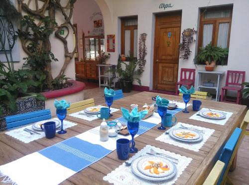 a wooden table with plates of food on it at El Diablo y la Sandia B&B in Oaxaca City