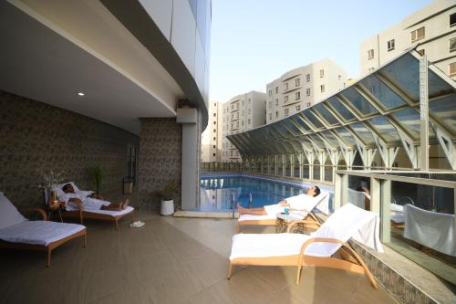 a building with a pool and people sitting on a patio at Wahaj Boulevard Hotel in Kuwait