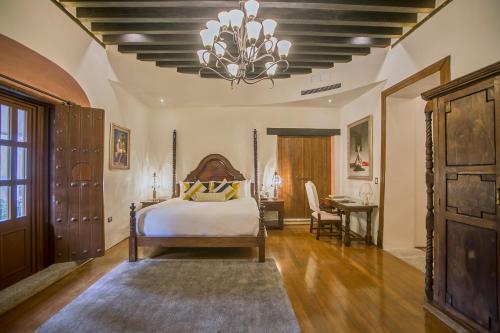 a bedroom with a bed and a chandelier at Casona de los Sapos Hotel Boutique in Puebla
