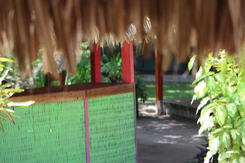 a table with red posts in a garden with plants at Eco Hotel Las Palmeras in Isla Grande