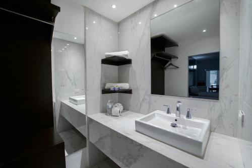 Baño blanco con lavabo y espejo en Stay Inn Hotels en Reynosa