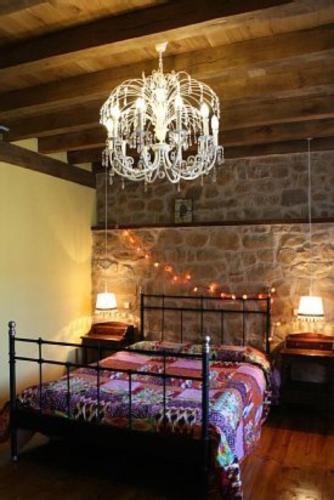 a bedroom with a bed and a chandelier at La Torre de San Esteban in Bárcena de Ebro