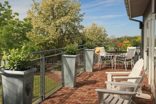 a patio with white chairs and tables on a fence at The Inn at Abeja in Walla Walla