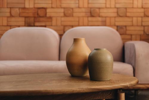 two vases sitting on top of a wooden table at Casa Ixaya by Barrio México in Guadalajara