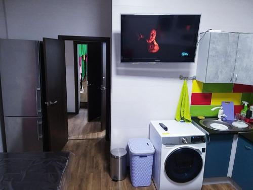 a room with a tv and a washing machine at Hostel 777 Vokzal in Kyiv