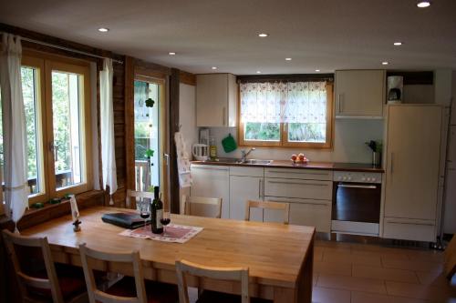 a kitchen with a wooden table with a bottle of wine at Chalet Samson in Zermatt