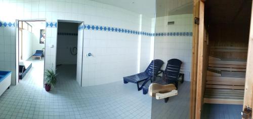 a waiting room with two blue chairs in a bathroom at Studio am Schluchsee mit Balkon Pool Fitness inkl in Schluchsee