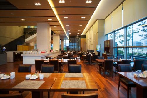 a restaurant with wooden tables and chairs and a cafeteria at Best Western Hotel Gunsan in Gunsan-si