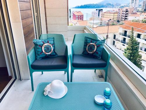 a balcony with two chairs and a table with hats on it at Marina Residence in Becici