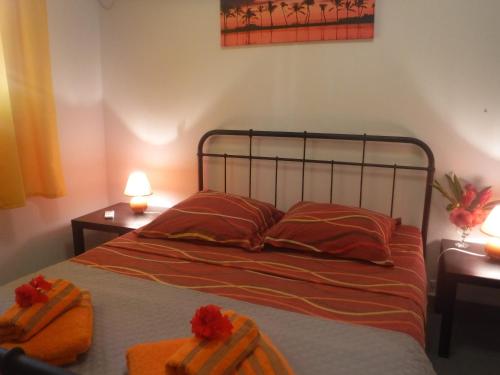 a bedroom with a bed with two orange towels on it at MAISON Vue et Accès Mer, piscine GUADELOUPE 6 personnes in Bouillante