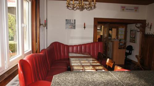 a living room with a red couch and a table at Gasthof Keilbach in Sindelfingen