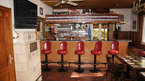 a bar with red bar stools in a restaurant at Gasthof Keilbach in Sindelfingen