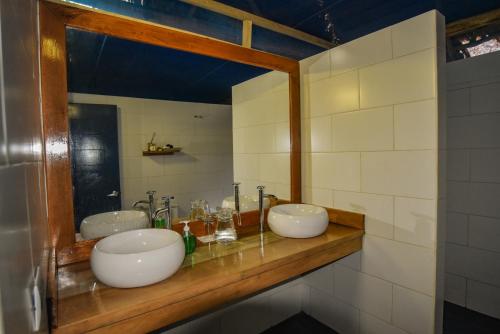 baño con 2 lavabos en una encimera de madera en Amazon Muyuna Lodge - All Inclusive, en Paraíso