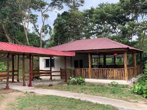 a small house with a red roof and a porch at Candurumy Lodge in Tena