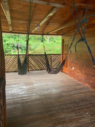 a room with two hammocks in a room with wood floors at Candurumy Lodge in Tena