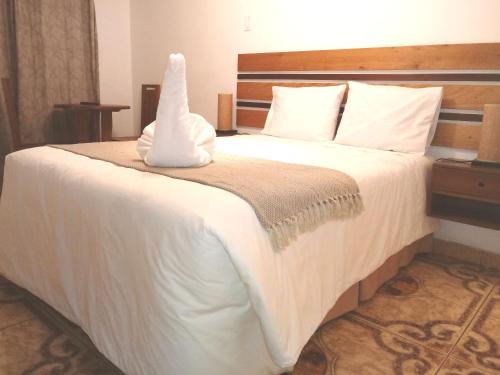 a bedroom with a bed with a white comforter at Lunandina Huaraz in Huaraz