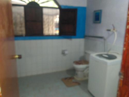 a bathroom with a toilet and a window at El Garaje Hostal in Taganga