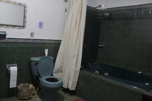 W łazience znajduje się niebieska toaleta i wanna. w obiekcie Casa Familiar w mieście Antigua Guatemala