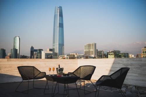 a table and chairs on a rooftop with a city skyline at Ladera Boutique Hotel in Santiago